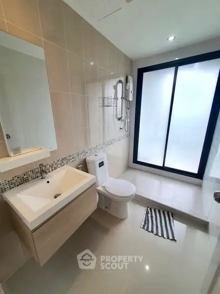 Modern bathroom with sleek fixtures and large frosted glass window for privacy.