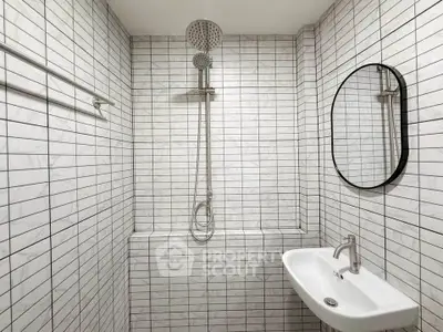 Modern minimalist bathroom with sleek shower and stylish round mirror