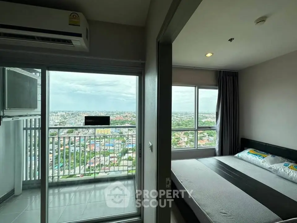 Modern bedroom with balcony offering stunning city views in high-rise apartment.