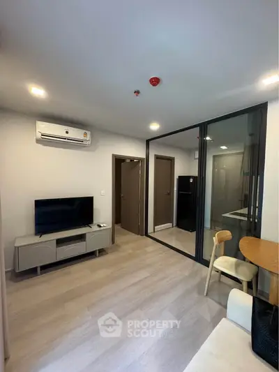 Modern living room with sleek design, featuring a TV, air conditioning, and stylish furniture.