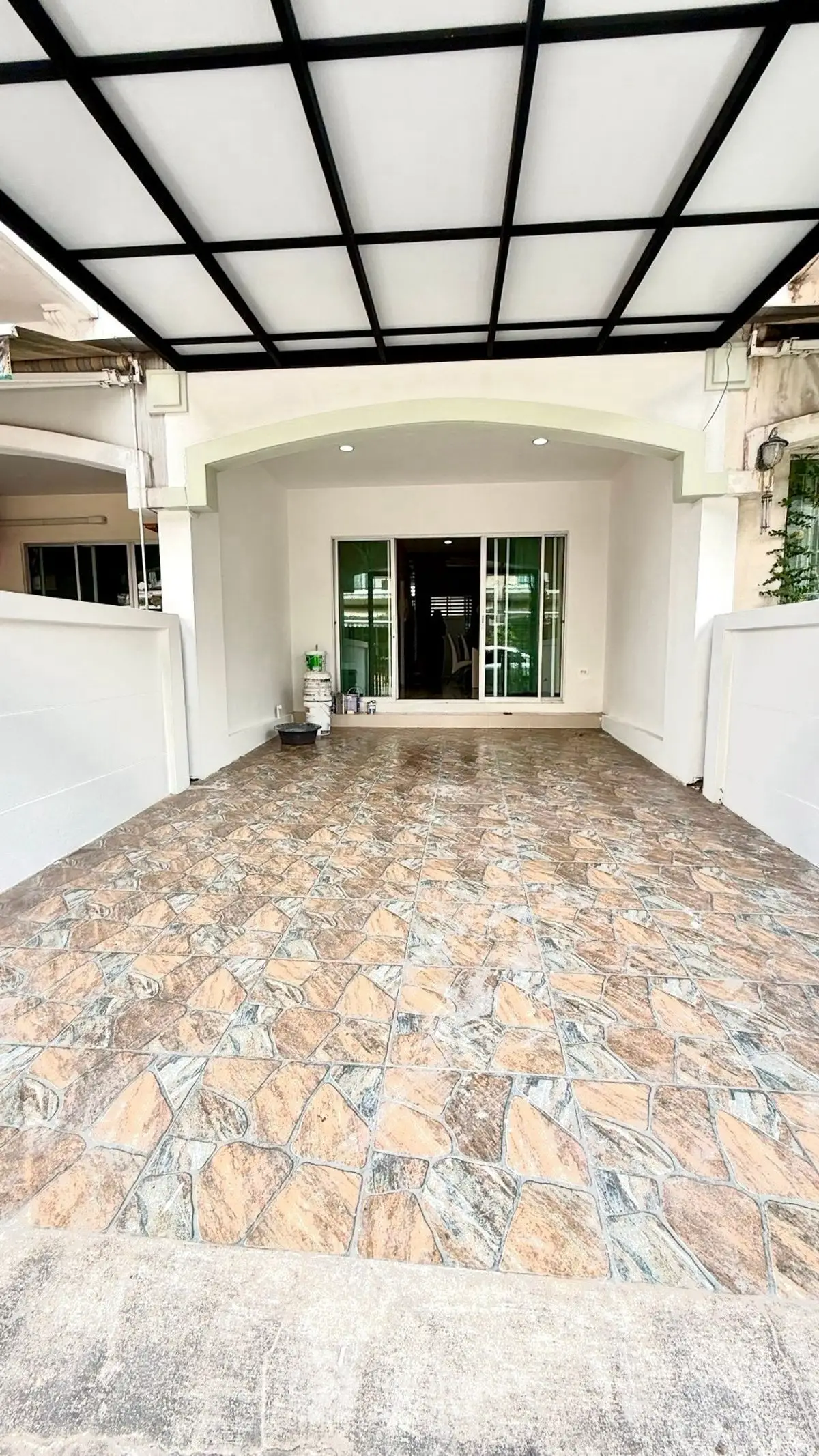Spacious covered parking area with stylish stone tile flooring and modern design.