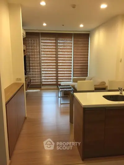 Modern living room with open kitchen and wooden flooring