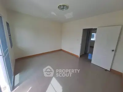 Spacious empty room with natural light and tiled flooring, ready for customization.