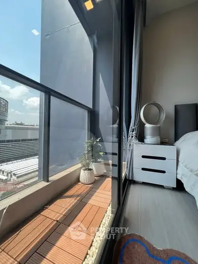 Modern bedroom with large window and city view, featuring stylish decor and natural light.