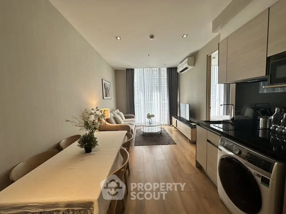 Modern open-plan living room and kitchen with stylish decor and natural light.