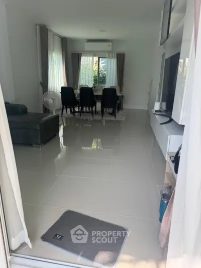 Spacious modern living room with sleek tile flooring and elegant dining area