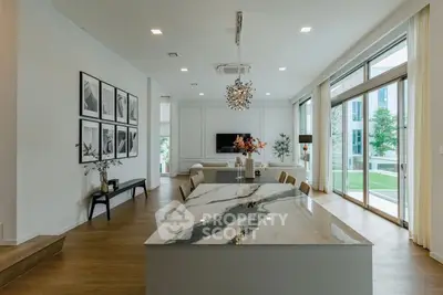 Luxurious open-plan living room with elegant decor and large windows for natural light.