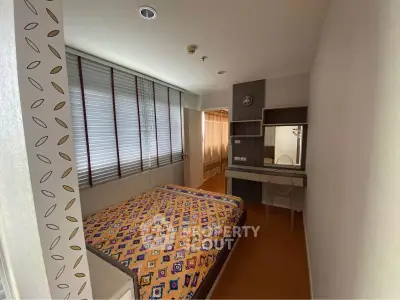 Cozy bedroom with modern decor and ample natural light in a stylish apartment.