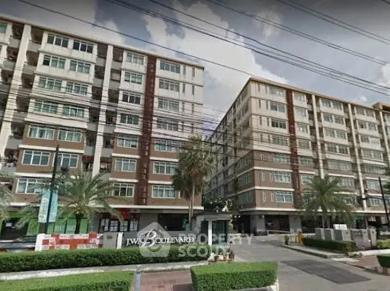 Modern apartment complex with lush landscaping and spacious balconies.