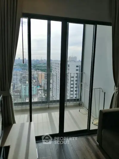 Stunning high-rise apartment with floor-to-ceiling windows and city view balcony.