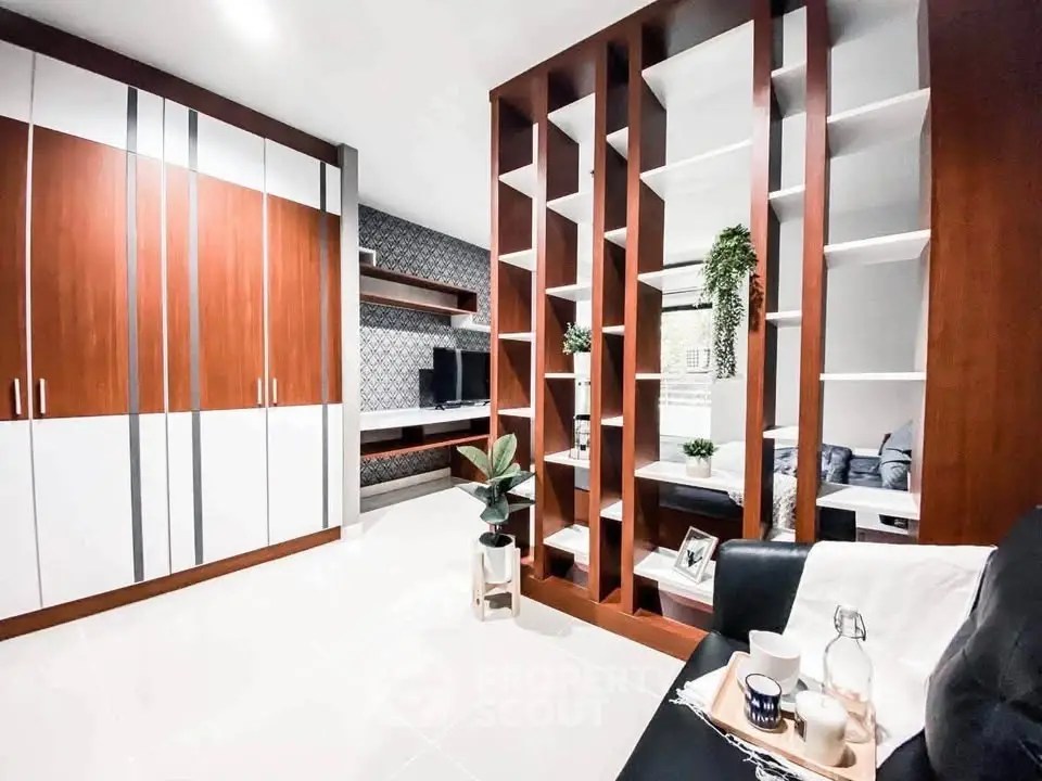 Modern living room with stylish wooden shelving and sleek storage solutions.