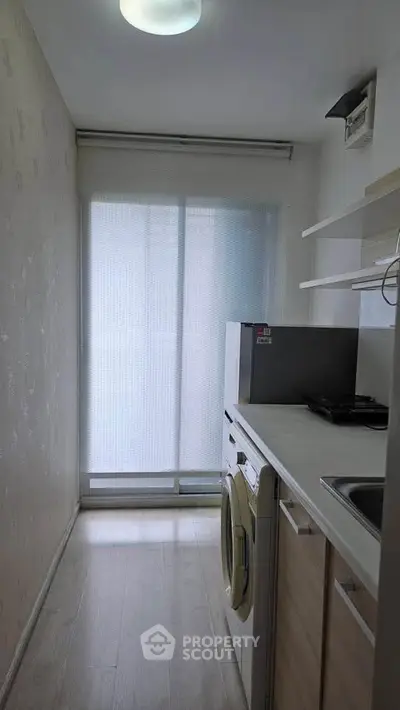 Compact kitchen with washing machine and gas stove, ideal for urban living.