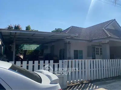 Charming suburban house with a tiled roof and white picket fence, perfect for family living.