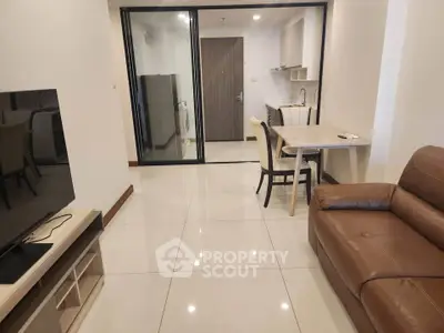 Modern living room with sleek furniture and open kitchen layout in a stylish apartment.