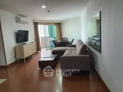 Spacious living room with modern furniture and balcony access in urban apartment.