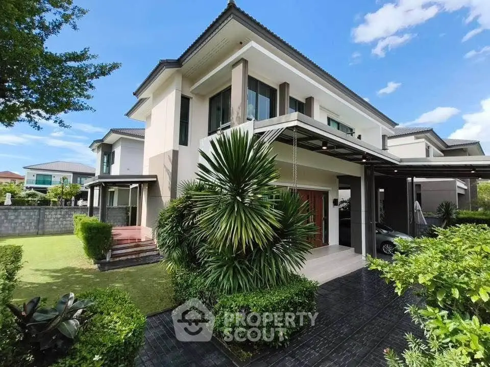 Luxurious modern house with lush garden and spacious driveway, perfect for family living.