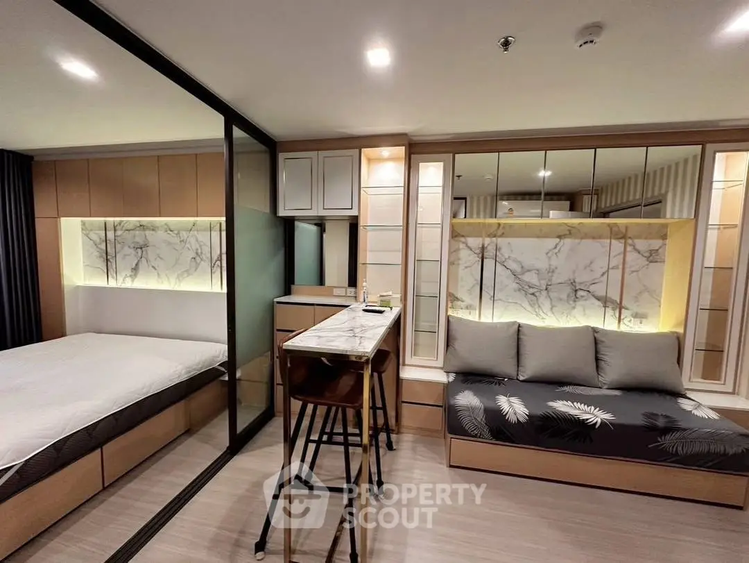 Modern studio apartment with stylish interior design featuring a cozy bed, sleek kitchen, and elegant decor.