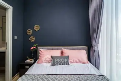 Cozy bedroom with elegant decor and large window for natural light.