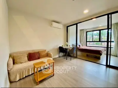 Modern studio apartment with open living area and cozy bedroom, featuring large windows and stylish decor.