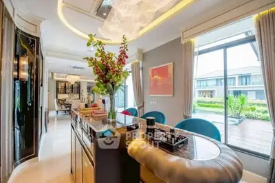 Luxurious modern living room with elegant decor and large windows overlooking a serene garden view.