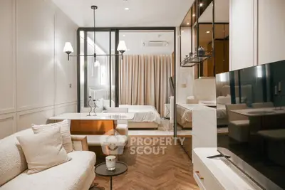 Luxurious modern living room with elegant decor and open layout leading to a cozy bedroom.