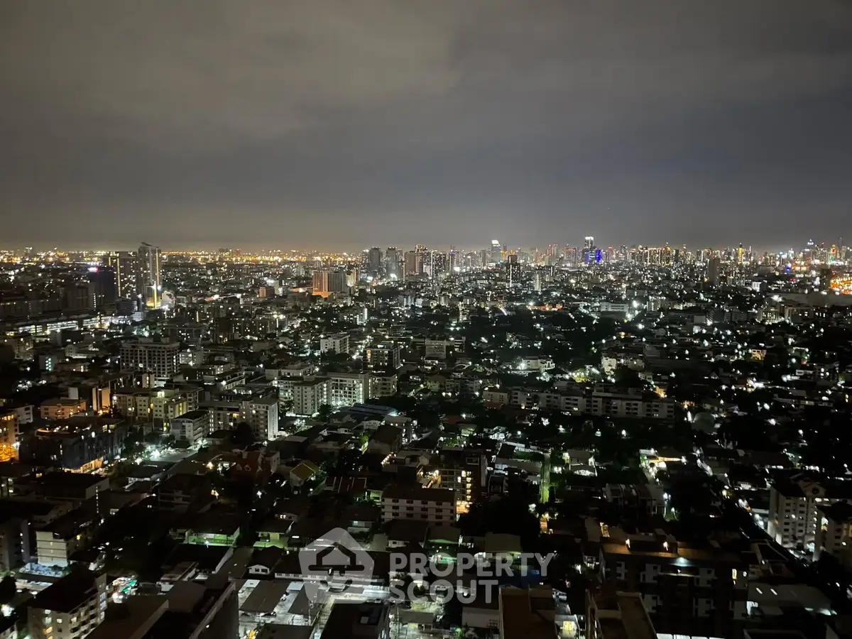 Stunning cityscape view from high-rise apartment at night, showcasing vibrant urban lights.