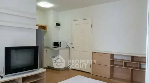 Cozy studio apartment with modern kitchen and entertainment setup