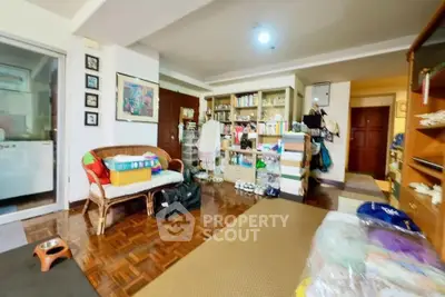 Spacious living room with parquet flooring and ample storage in a cozy home.