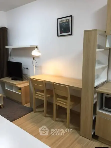 Cozy study area with wooden furniture and modern decor in a compact apartment.