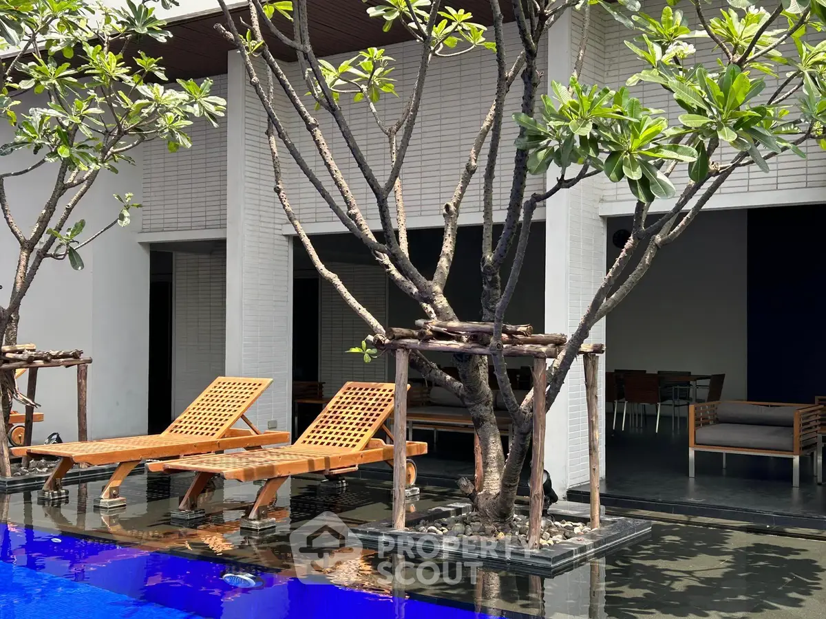 Luxurious poolside area with stylish loungers and lush greenery for ultimate relaxation.