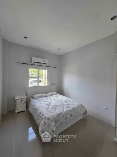 Cozy bedroom with natural light and modern air conditioning unit.