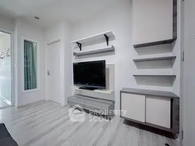 Modern living room with sleek TV setup and stylish shelving in a contemporary apartment.