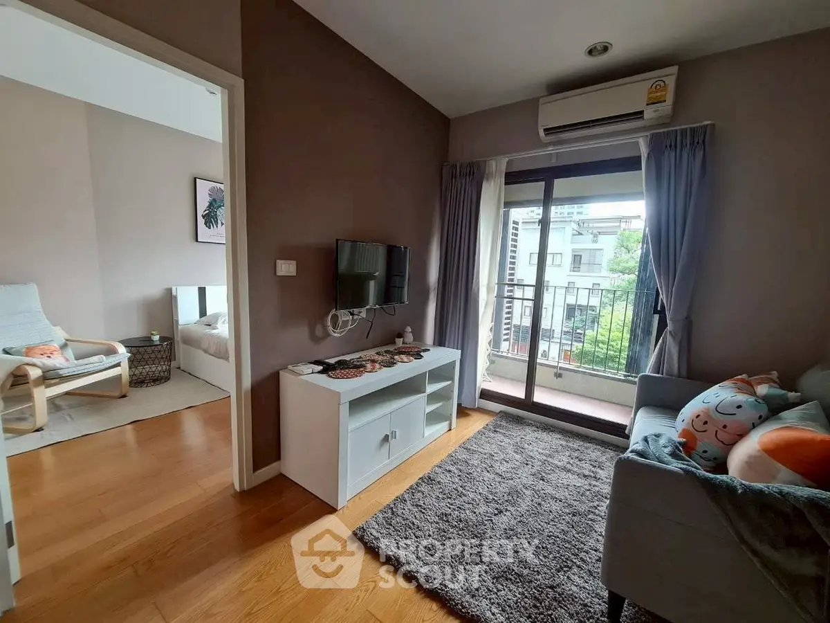 Cozy living room with balcony view, modern decor, and natural light