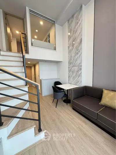 Modern duplex living room with stylish staircase and cozy seating area