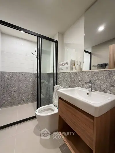 Modern bathroom with sleek design, featuring a glass shower enclosure and stylish vanity.