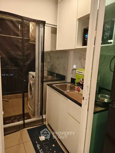 Modern kitchen with washing machine and sleek cabinetry in compact layout