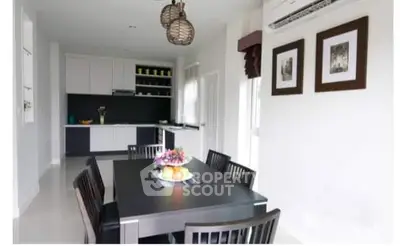 Modern dining area with sleek kitchen, stylish lighting, and elegant decor.