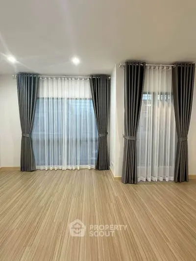 Spacious room with elegant floor-to-ceiling windows and modern curtains