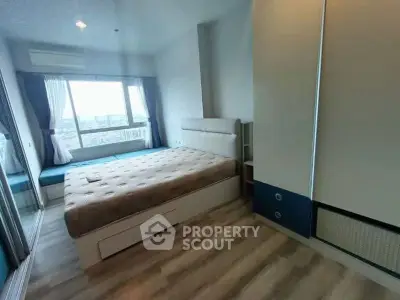 Modern bedroom with large window and stylish furniture in high-rise apartment