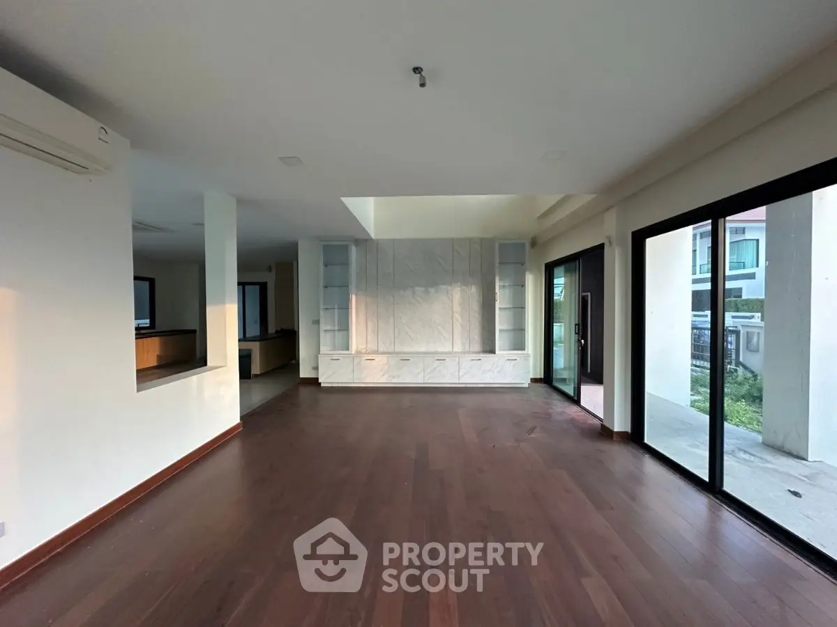 Spacious modern living room with hardwood floors and large windows