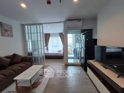 Modern open-plan living room with stylish decor and balcony view in a contemporary apartment.