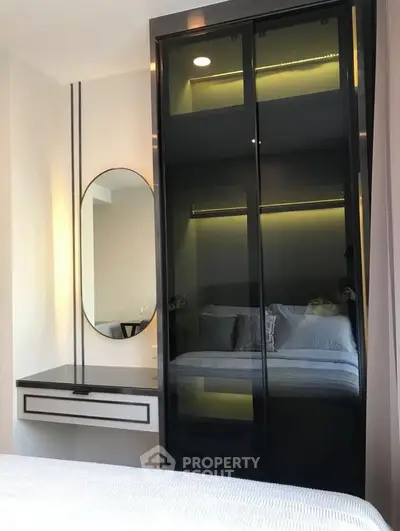 Modern bedroom with sleek black wardrobe and stylish vanity mirror