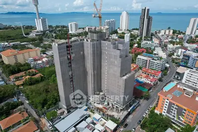 Stunning high-rise building under construction with ocean view in vibrant cityscape.