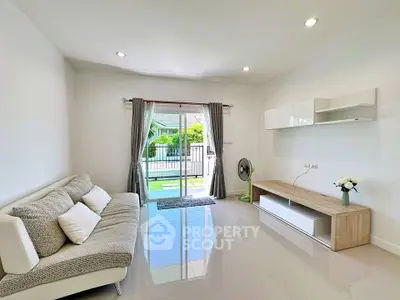 Bright modern living room with sleek furniture and garden view, perfect for relaxation.