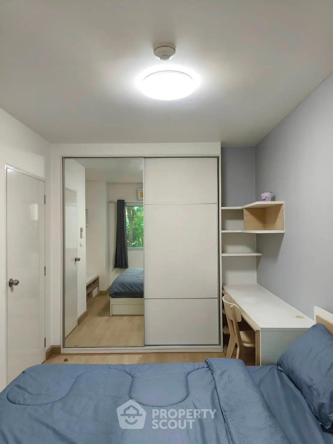 Modern bedroom with sleek wardrobe and study desk, perfect for urban living.