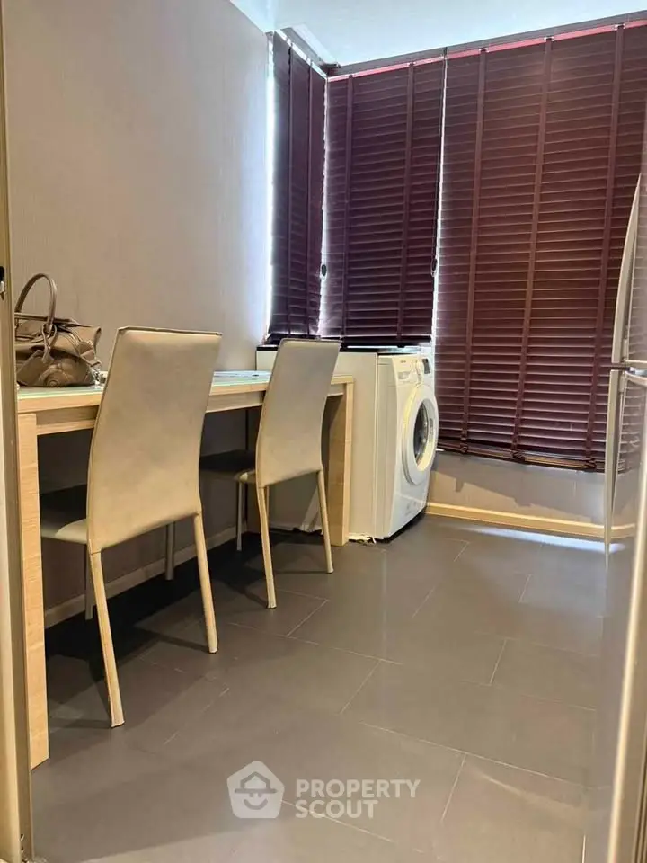 Modern laundry room with washing machine and stylish chairs, perfect for efficient home living.