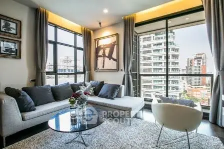 Modern living room with large windows and city view, featuring stylish furniture and elegant decor.