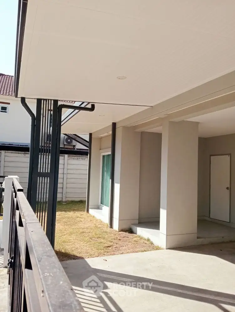 Modern exterior view of a residential property with covered patio and lawn.