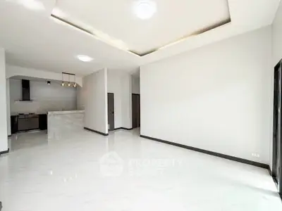 Spacious modern living room with open kitchen and elegant lighting