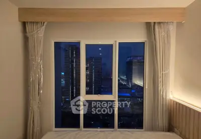 Modern bedroom with large window offering stunning cityscape view at night.